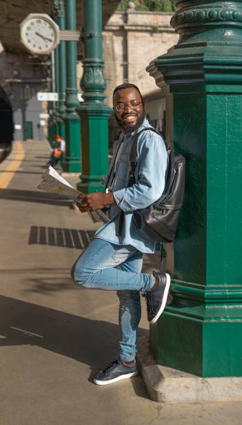 istock Happy young man with map at terminal train station 1481881926
