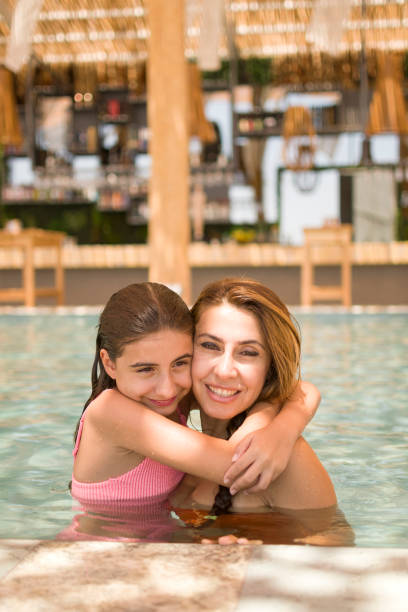 istock Mother and her daughter having fun in pool 1481883972