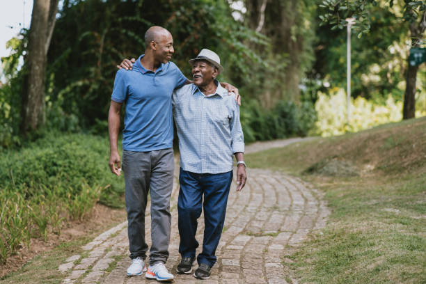 Portrait of elderly father and adult son walking stock photo