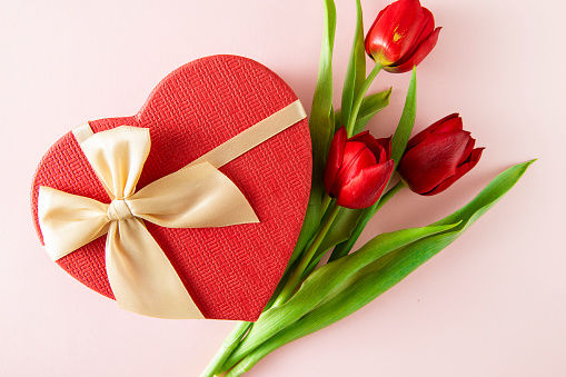 Mother’s Day concept with red tulips and heart shaped gift box