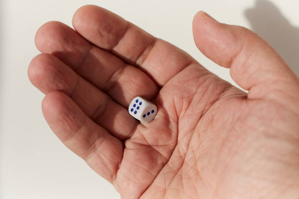 istock Dice in a male hand on a white background 1481894873