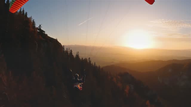 Freedom paragliding flight over rocky forest nature at peaceful sunrise in autumn mountains, Adrenaline Adventure Sport