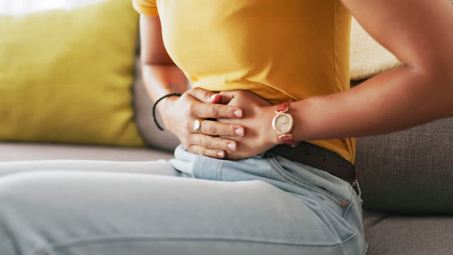 Period, pain and hands of black woman on stomach holding belly for cramps, ache and menstruation problem. Health, endometriosis and girl with hand on abdomen with pms, menstrual ache and digestion