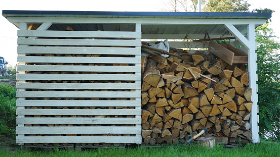 Wood shed. Wood storage in the garden. Storaging wood for the winter.