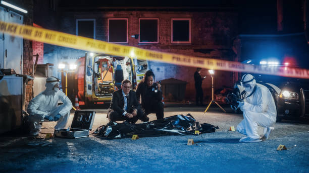 female police officer and male investigator working as a team on solving a murder case at the crime scene. professional investigation team looking through patterns in the evidence to break the case - csi imagens e fotografias de stock