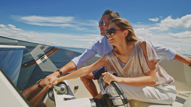 SLO MO Woman and man driving the yacht and having fun