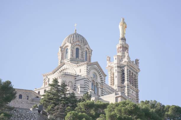 toma de ángulo bajo de la catedral de notre dame de lagarde en marsella, francia, sobre un afloramiento rocoso - notre dame de la garde fotografías e imágenes de stock