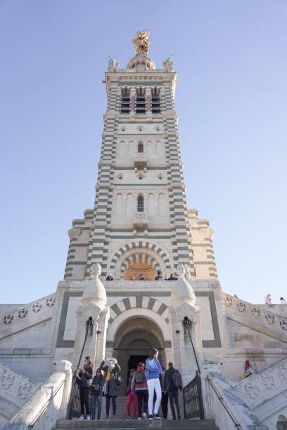 toma de ángulo bajo de la catedral de notre dame de lagarde en marsella, francia contra el cielo azul - notre dame de la garde fotografías e imágenes de stock