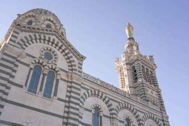 toma de ángulo bajo de la catedral de notre dame de lagarde en marsella, francia contra el cielo azul - notre dame de la garde fotografías e imágenes de stock