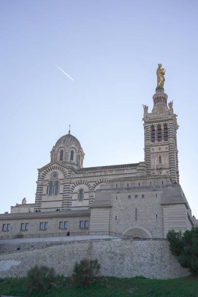 toma de ángulo bajo de la catedral de notre dame de lagarde en marsella, francia contra el cielo azul - notre dame de la garde fotografías e imágenes de stock