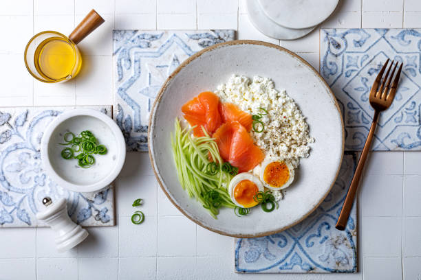 istock Cottage cheese with smoked salmon, cucumber, soft boiled egg and fresh chives. Savory hight protein breakfast bowl. 1481906018