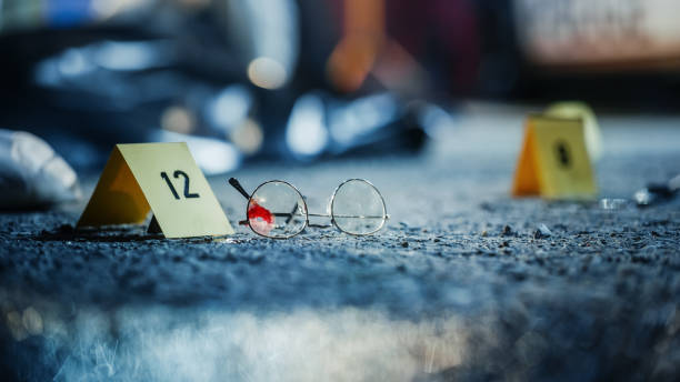 a ground level shot of evidence on a crime scene investigated by forensics. a photo of numbered marker next to bloody glasses potentially belonging and left behind by the killer - csi imagens e fotografias de stock