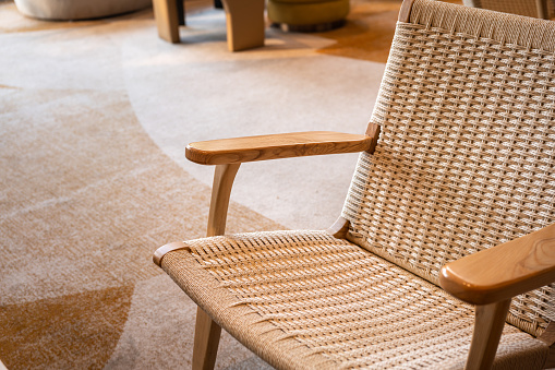 A wooden weave armchair seat in cozy classic design at the living room. Interior decoration furniture object, close-up and selective focus.