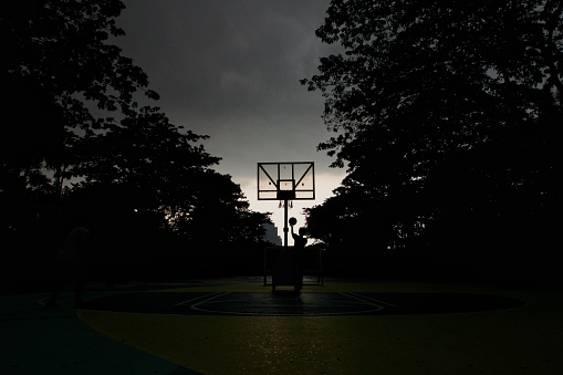 A man played basketball on a cloudy day