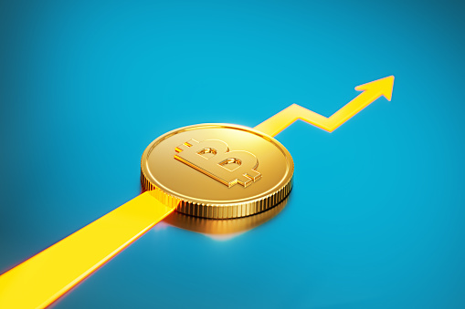 Bitcoin sitting over an orange arrow on blue background. Horizontal composition with copy space. Finance concept.