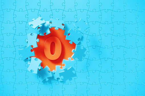 Blue jigsaw puzzle pieces revealing number 0 on orange background. Horizontal composition with copy space. Solution concept.