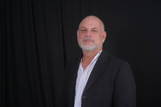 Handsome middle-aged man in a suit posing against black background. confident business man