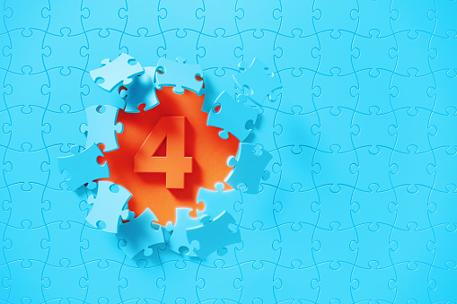 Blue jigsaw puzzle pieces revealing number 4 on orange background. Horizontal composition with copy space. Solution concept.