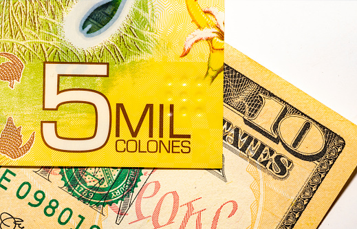 Costa Rican Colon and dollars still life background.