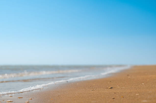 Closeup of sand on beach and blue summer sky. Panoramic beach landscape. Empty tropical beach and seascape