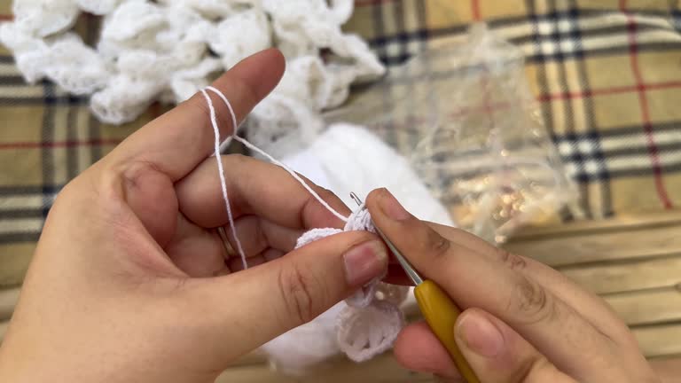 Close up on the young woman's hands knitting.