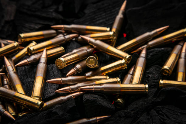 istock Cartridges for automatic carbine caliber .223 on charcoal. Ammunition for automatic and semi-automatic rifles. Dark background. 1481927882