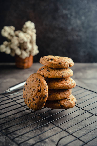istock Homemade chocolate chip cookies on black baking cooling tray and abstract background 1481939018