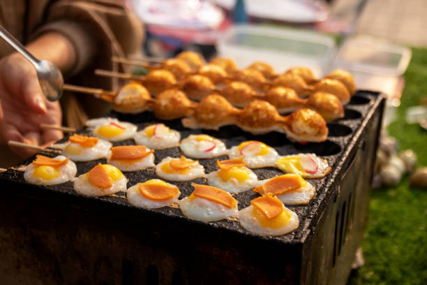 istock Fried Quail eggs in bamboo skewers on pothole pan. Drop each egg in a small ramekin gently slide it into the hot oil. Serve warm with salt and ground pepper. Thai appetizer at street food market. 1481942844