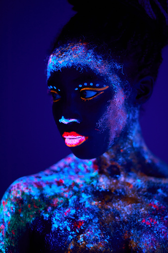 attractive young female model in bright blacklight bodyart, chamring calm female in mindful, peaceful, stand looking at side, posing at camera. body art, fantastic, fluorescent, luminescence