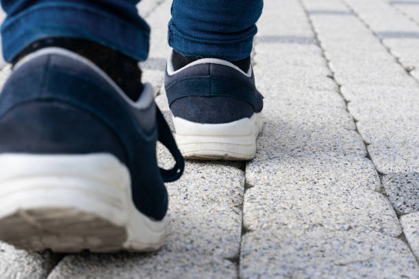 istock Feet in running shoes are walking forward on stony road. 1481950923