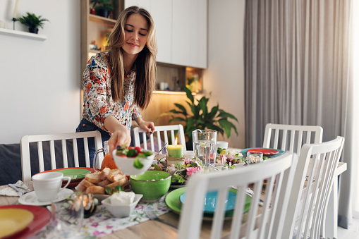 Teenage girl setting the table for traditional Easter breakfast. In eastern European Christian tradition the Easter breakfast is the most important family meal of  Easter.
Canon R5