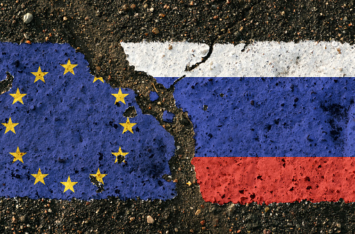 On the pavement are images of the flags of the European Union and Russia, as a symbol of confrontation. Conceptual image.