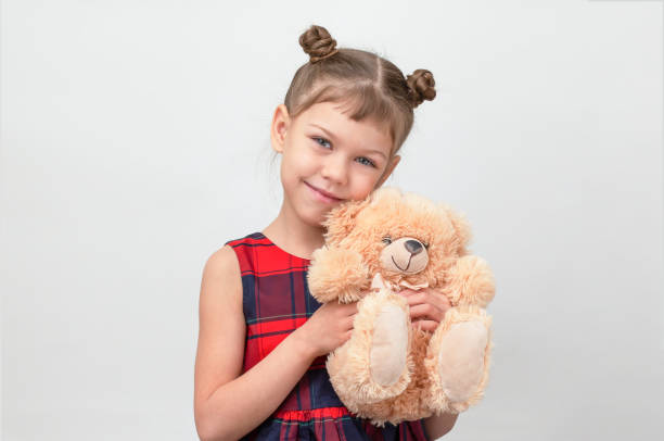 istock Happy and smiling child hugging teddy bear on white background 1481972197
