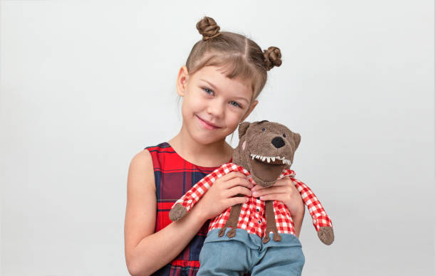 Happy and smiling child hugging wolf toy on white background