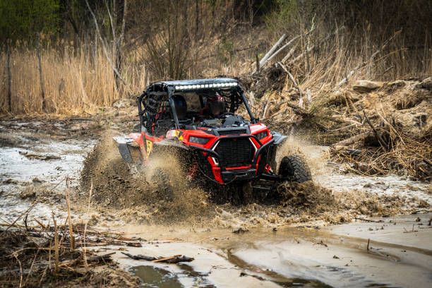 istock ATV/UTV/4x4 driving throw splashing past a muddy large puddle in forest 1481972615