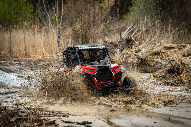 istock ATV/UTV/4x4 driving throw splashing past a muddy large puddle in forest 1481972680