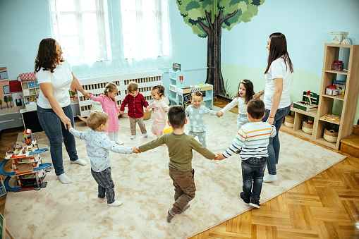 Preschool and kindergarten teachers, dancing in a circle