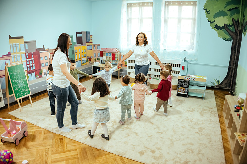 Preschool and kindergarten teachers, dancing in a circle