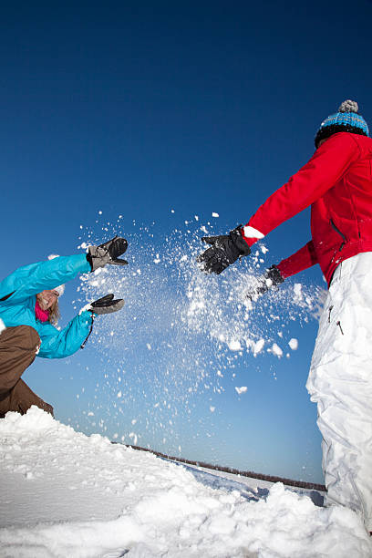 pareja jugando con la nieve en campo - clear sky diagonal snow winter fotografías e imágenes de stock