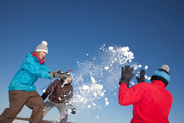 friends having snowball fight outdoors - clear sky diagonal snow winter fotografías e imágenes de stock