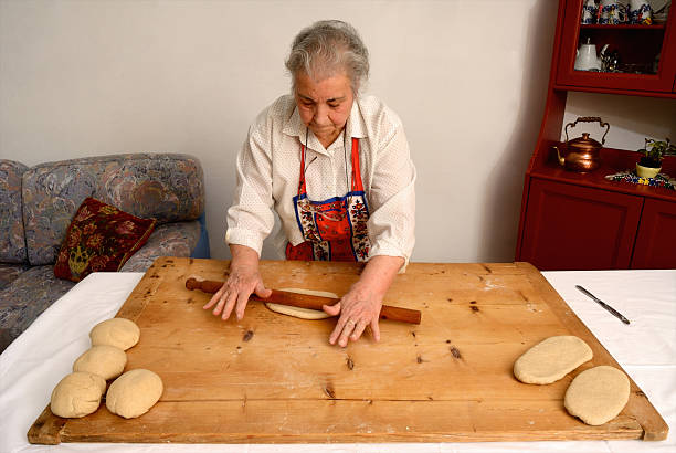 Older woman rolling dough on board  costantino stock pictures, royalty-free photos & images