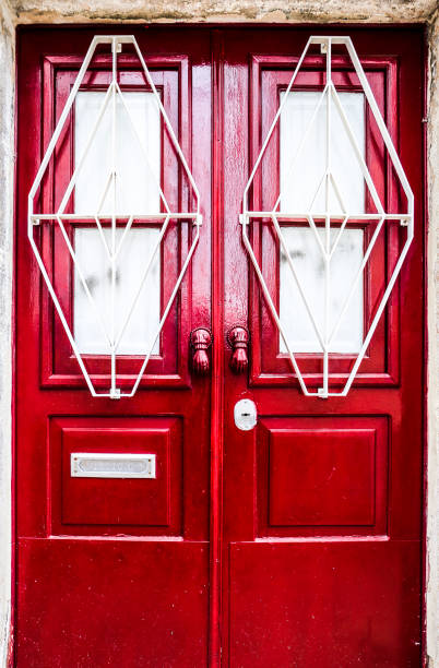 istock Old red door with white wrought details 1481991357