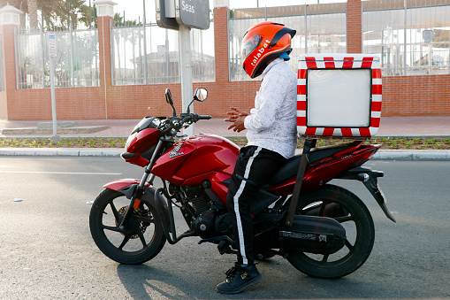 Dubai, United Arab Emirates - April 12, 2023 man on a motor bike for online delivery