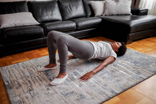 mujer practicando yoga, el ejercicio del puente glute, dvi pada pithasana pose - dvi fotografías e imágenes de stock