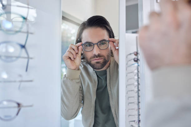 istock Optometry, glasses choice and man check mirror for vision, eye care and customer experience in store with lens frame. Young client or person eyes healthcare, retail and shop test for optical wellness 1481999968