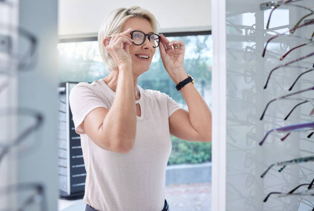 woman, glasses and eye care shopping for lens or frame for vision and wellness in optometry store. happy customer person making choice or decision for retail sale with health insurance at optics shop - human eye eyesight optometrist lens imagens e fotografias de stock