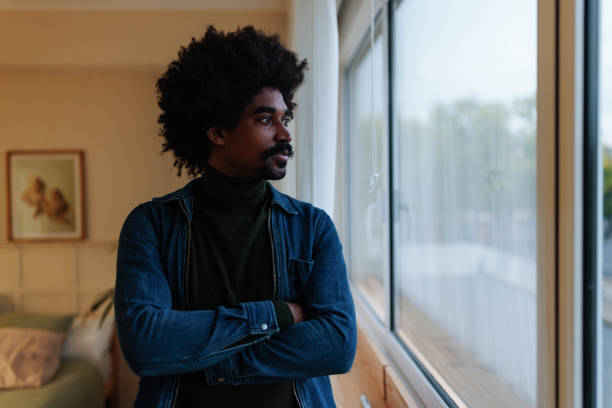 istock Young adult man looking through window. 1482001638