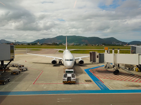 jet plane being towed to the departure terminal at Hercilio Luz airport in the city of Florianopolis, SC, BRAZIL.