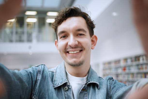 istock Education, selfie and man in library, smile and cheerful for knowledge, learning and on break. Portrait, male student and academic on campus, casual and happiness for results, achievement and relax 1482006256