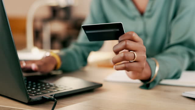 Laptop, credit card and woman hands for business online shopping, transaction or fintech payment in night office. Professional black person typing her banking information on computer or financial app